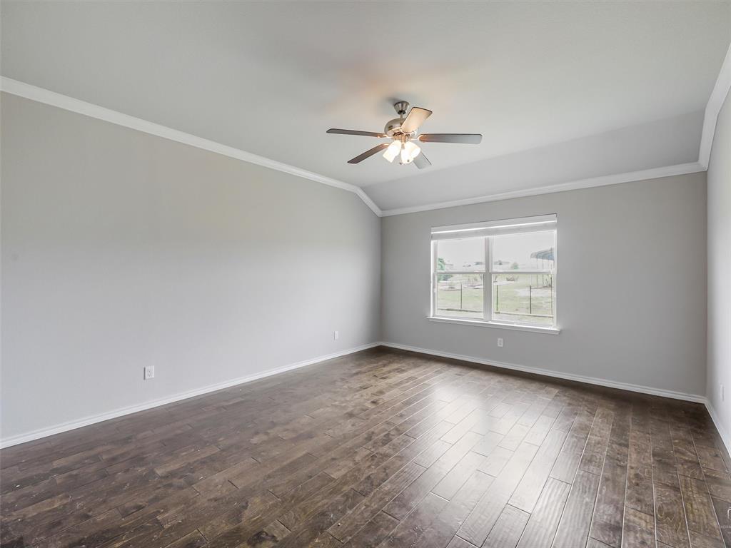 132 County Road 4213 Decatur, TX 76234 - Photo 11 of 27 an empty room with wooden floor chandelier fan and windows