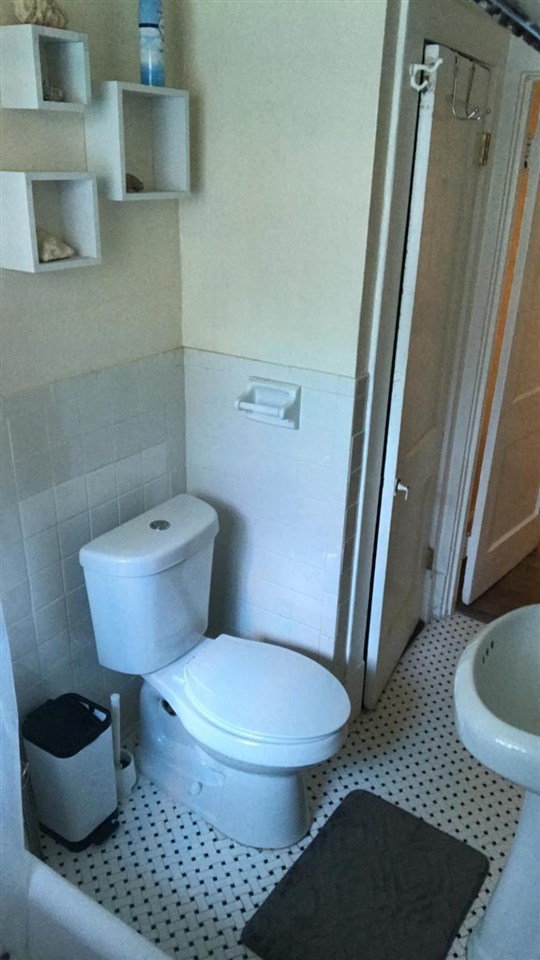 145 North Rembert Street Memphis, TN 38104 - Photo 17 of 25 a white toilet sitting next to a bathroom sink and vanity