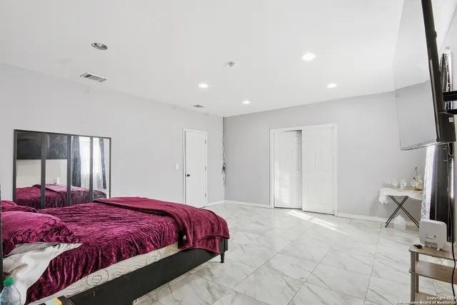 a spacious bedroom with a bed and a chair in it