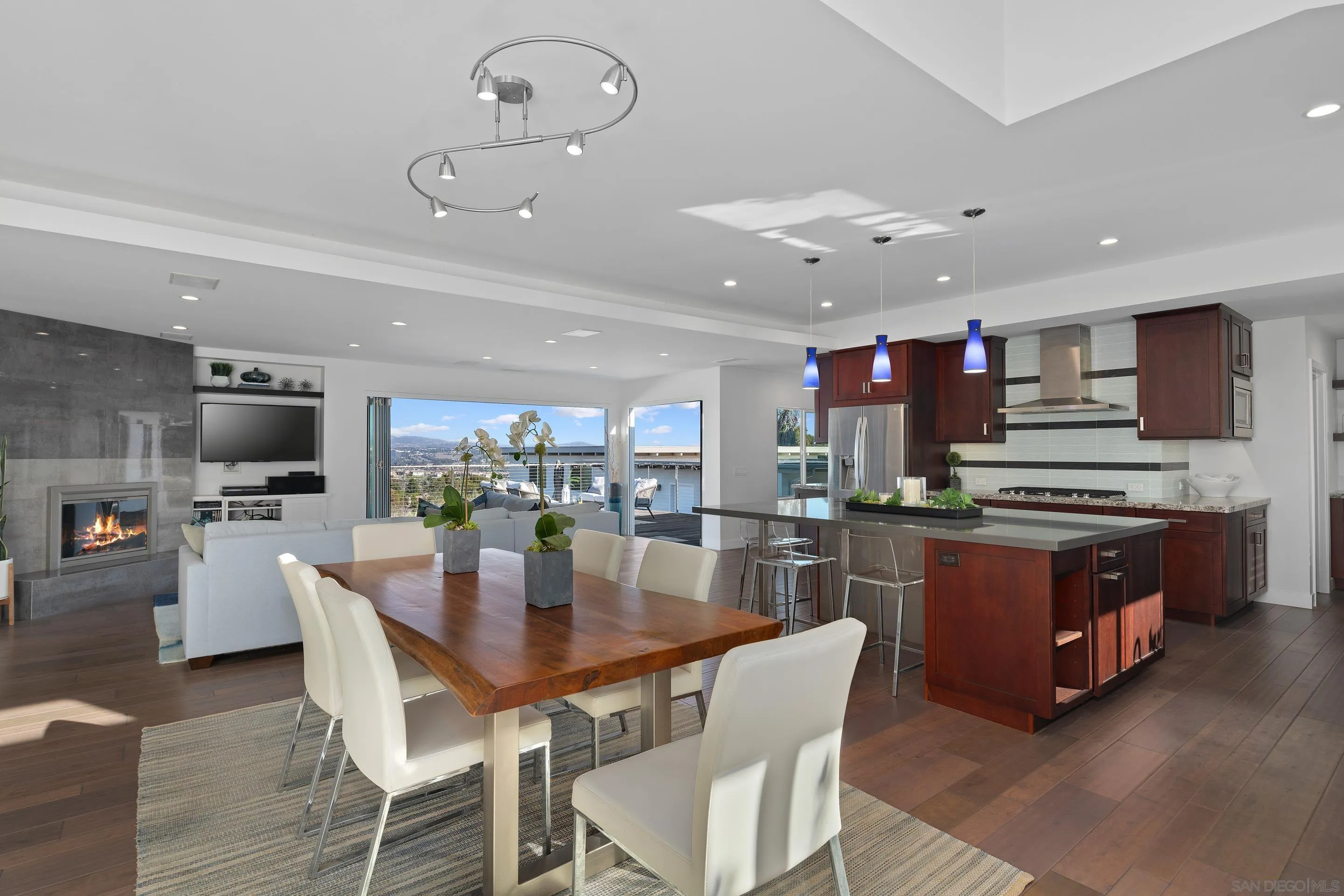 3800 Alder Avenue Carlsbad, CA 92008 - Photo 16 of 54 a kitchen with stainless steel appliances granite countertop a stove top oven a sink dishwasher a dining table and chairs with wooden floor