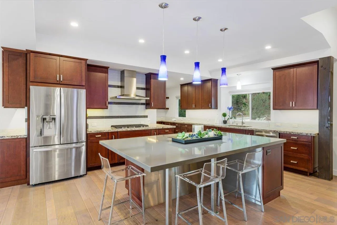 3800 Alder Avenue Carlsbad, CA 92008 - Photo 20 of 54 a kitchen with stainless steel appliances granite countertop a table chairs sink refrigerator and microwave