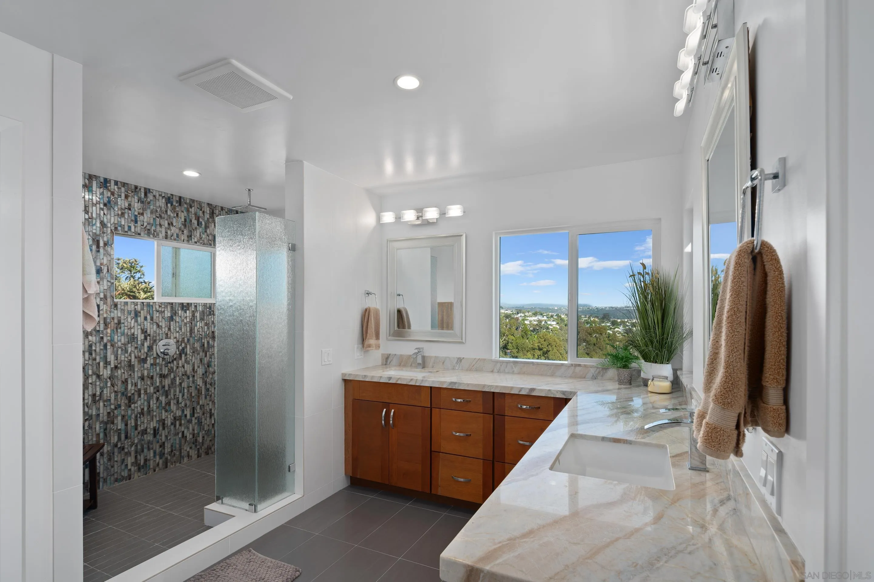 3800 Alder Avenue Carlsbad, CA 92008 - Photo 29 of 54 a large bathroom with a granite countertop sink a large mirror a shower and a bathtub