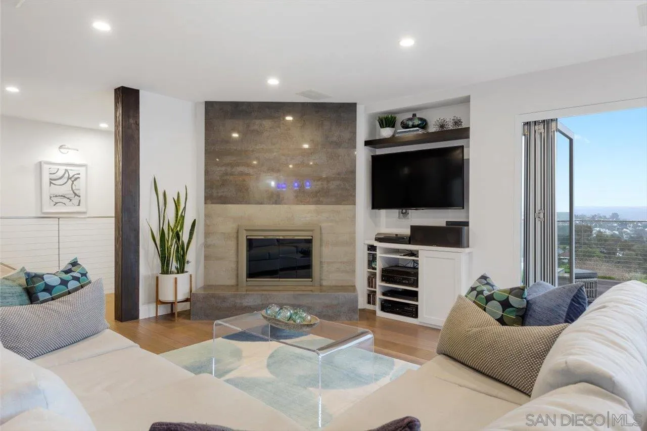 3800 Alder Avenue Carlsbad, CA 92008 - Photo 7 of 54 a living room with furniture a flat screen tv and a fireplace