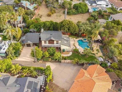 an aerial view of a house with a yard and lake view