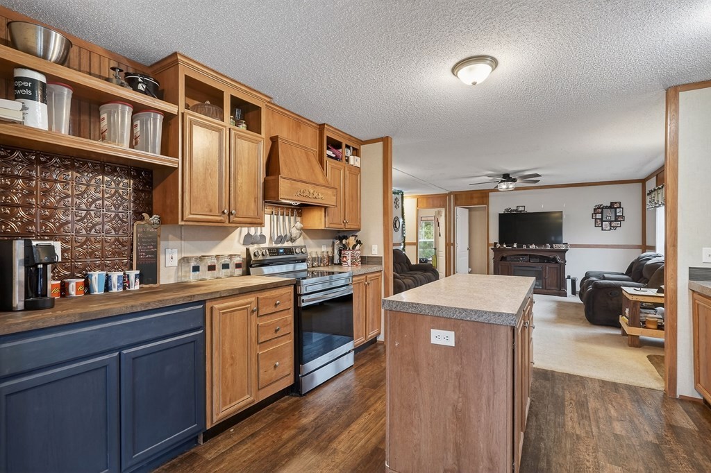 582 Doug Luna Road Walling, TN 38587 - Photo 13 of 47 a kitchen with stainless steel appliances granite countertop a stove top oven a sink dishwasher and a refrigerator with wooden floor