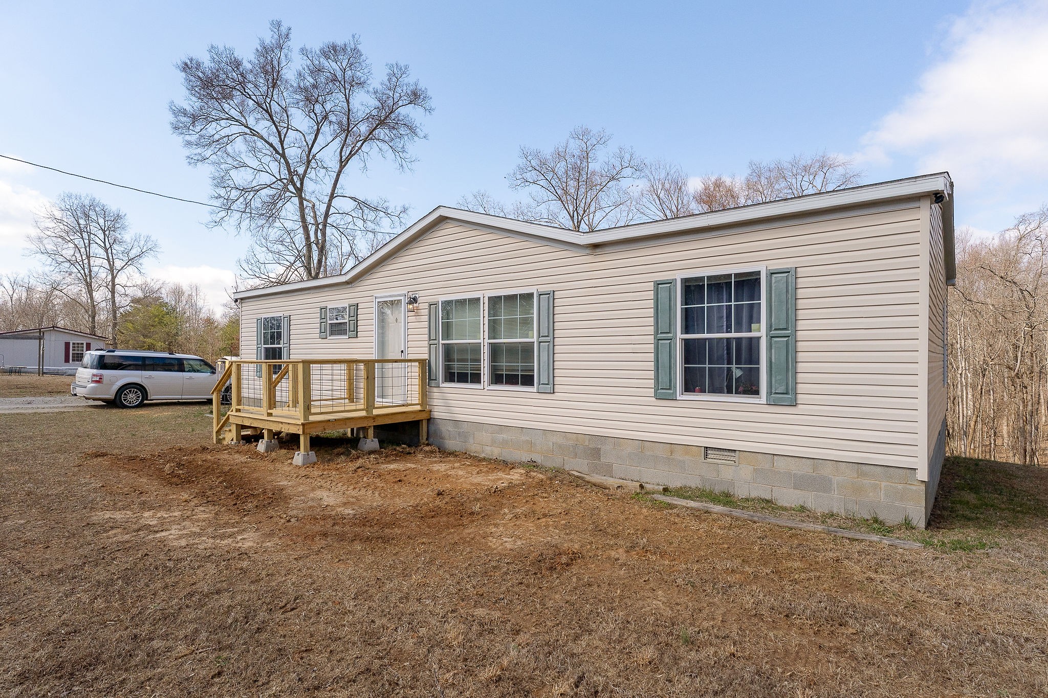 582 Doug Luna Road Walling, TN 38587 - Photo 2 of 47 a white house that has a small yard and couches chairs with wooden fence
