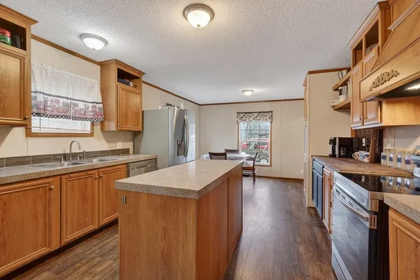 a kitchen with stainless steel appliances granite countertop a sink stove and refrigerator