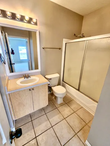 an empty room with closet and a chandelier fan