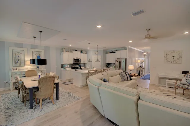 a living room with furniture and a dining table with kitchen view