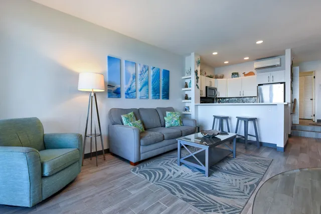 a living room with furniture and kitchen view