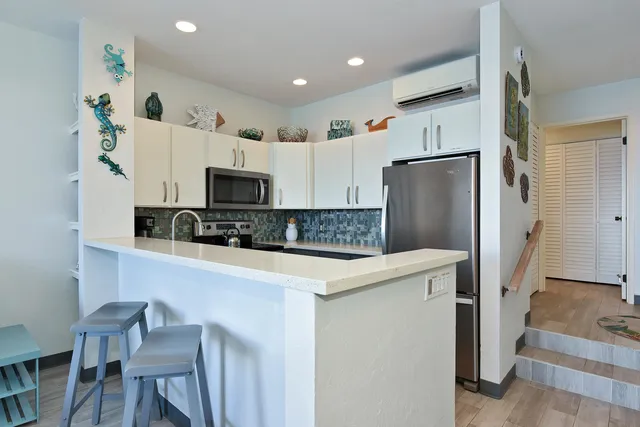 a kitchen with stainless steel appliances white cabinets and wooden floor