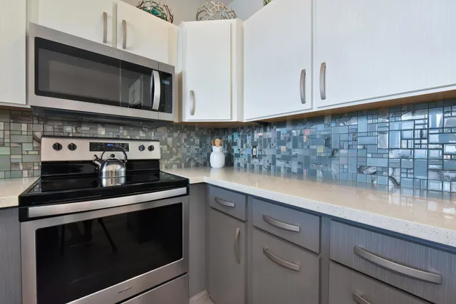 a kitchen with stainless steel appliances granite countertop white cabinets stove a sink and dishwasher