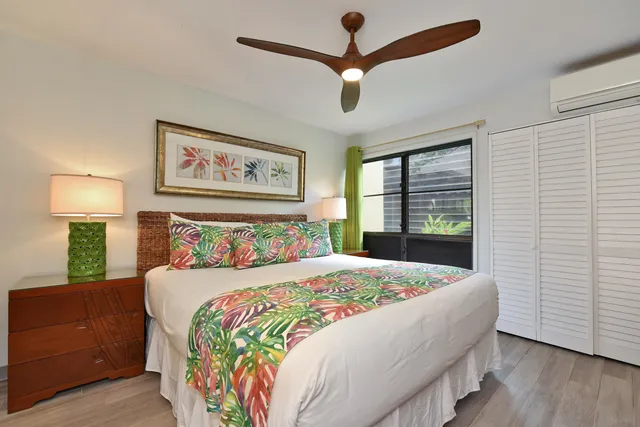 a bedroom with a bed and a lamp on dresser