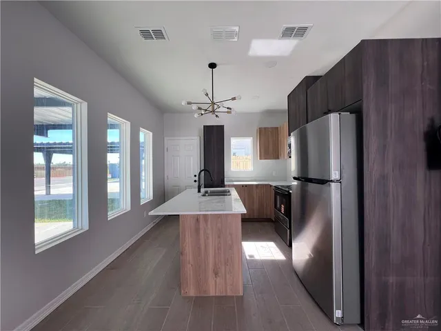 a view of a kitchen with a refrigerator and a view of living room