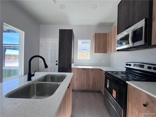 a kitchen with a sink and a stove top oven