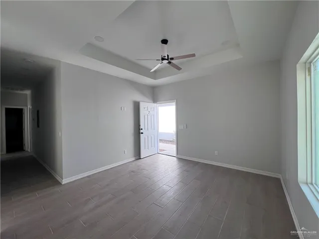 an empty room with a window and a ceiling fan