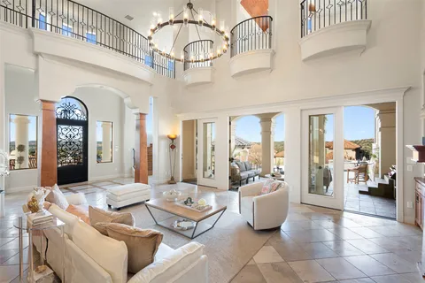 a living room with patio furniture and a chandelier