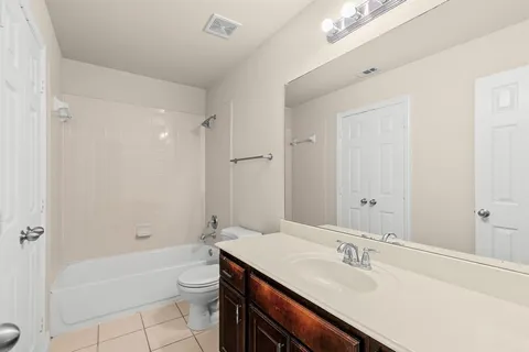 a bathroom with a granite countertop sink a toilet a bathtub and shower