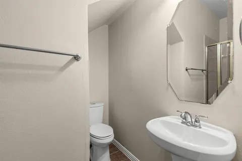 a bathroom with a sink toilet and a mirror