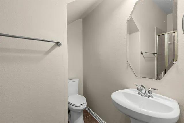 a bathroom with a sink toilet and a mirror
