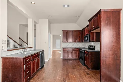 a kitchen with stainless steel appliances granite countertop a stove a sink dishwasher and a refrigerator