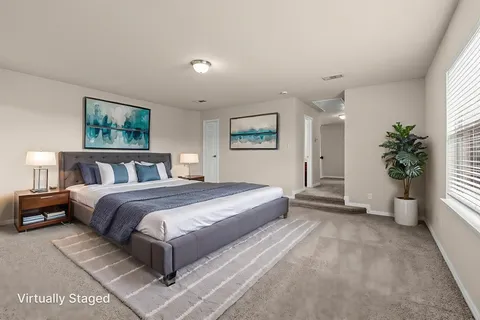 a spacious bedroom with a large bed and a potted plant