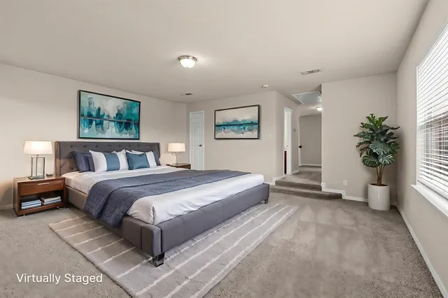 a spacious bedroom with a large bed and a potted plant