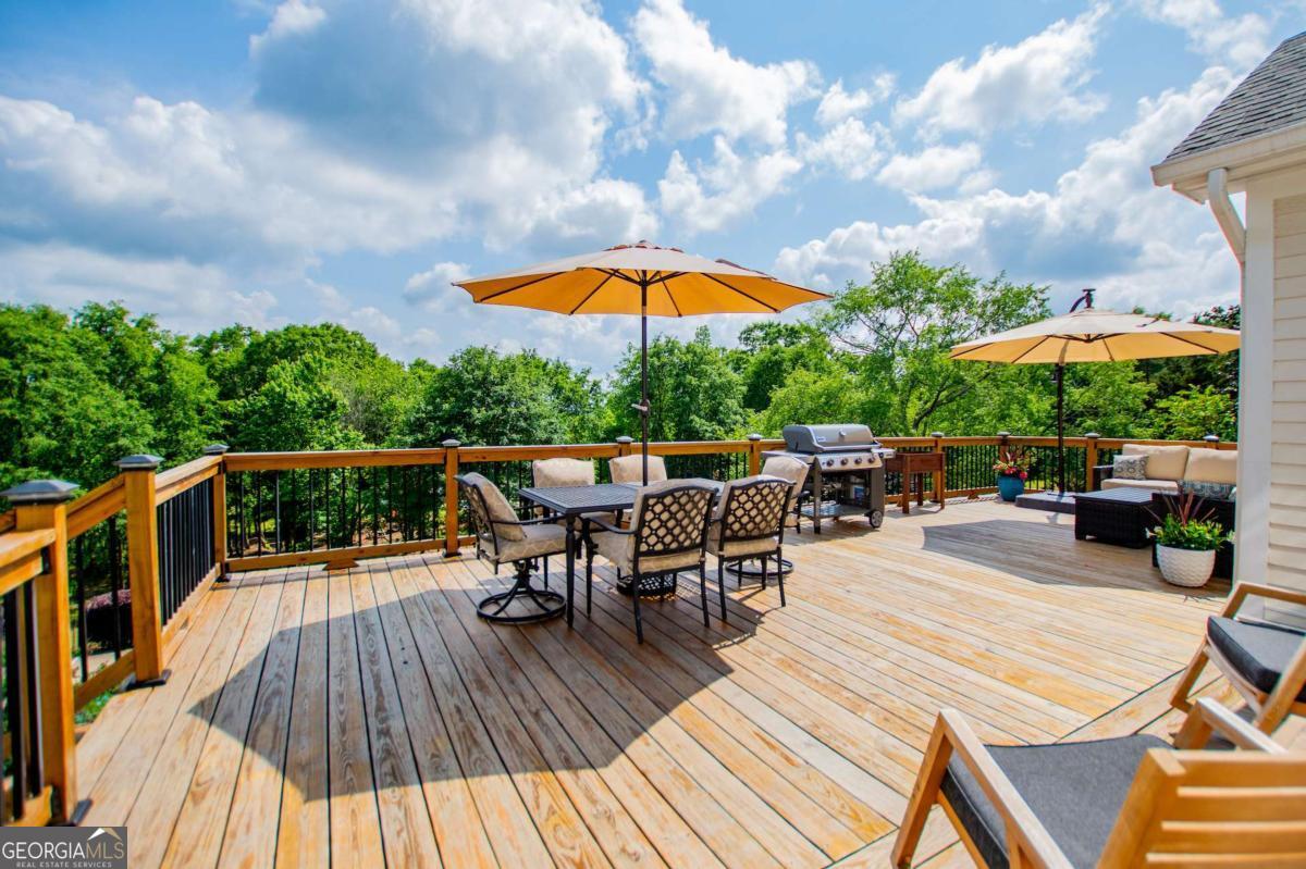 1745 Stripling Chapel Road Carrollton, GA 30116 - Photo 52 of 87 a view of a roof deck with table and chairs under an umbrella with wooden floor