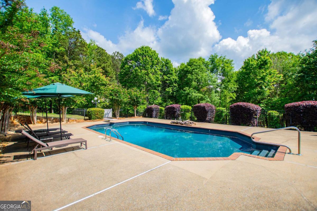 1745 Stripling Chapel Road Carrollton, GA 30116 - Photo 63 of 87 a view of pool with lawn chairs under an umbrella