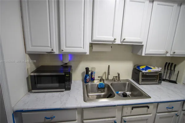 a kitchen with white cabinets and a stove