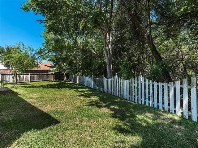 a view of a house with backyard and trees