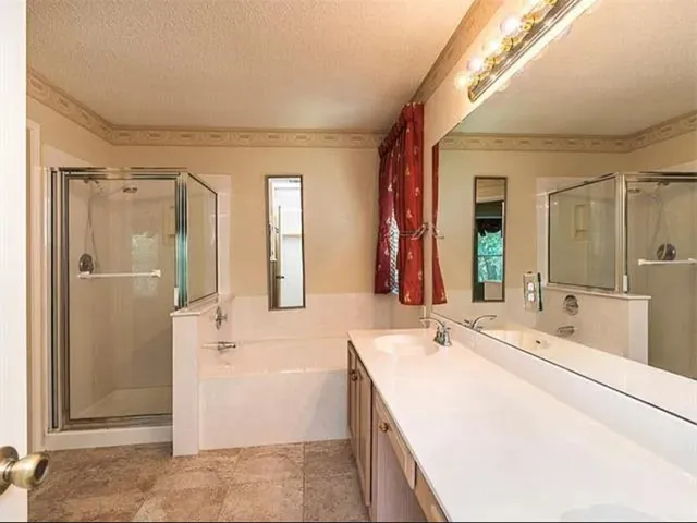 a bathroom with a tub sink and mirror