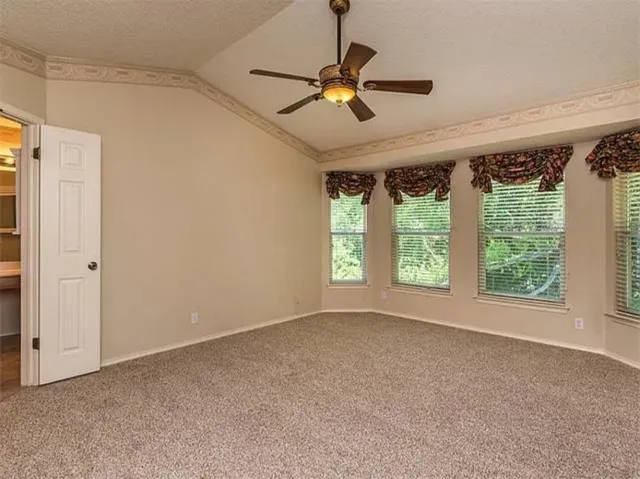 a view of room with a ceiling fan and window