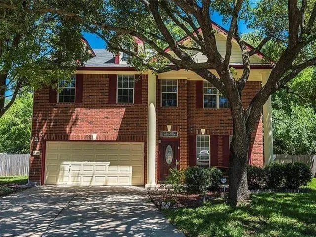 a front view of a house with a tree
