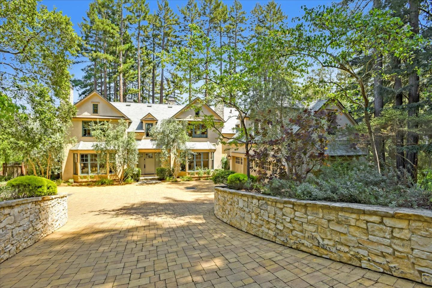 a front view of a house with a yard and trees