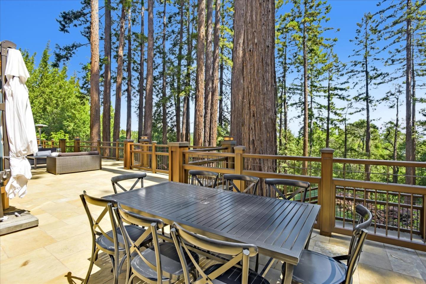 700 Patrol Road Woodside, CA 94062 - Photo 44 of 55 a view of a patio with table and chairs and potted plants with wooden floor and fence