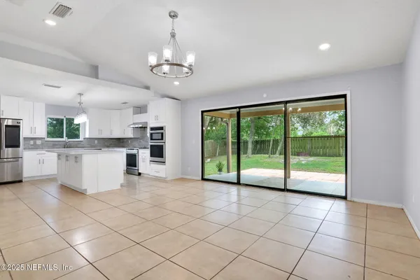 a view of a kitchen with furniture an empty space and a window