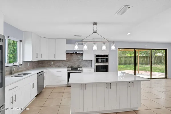 a kitchen with stainless steel appliances a sink stove and cabinets