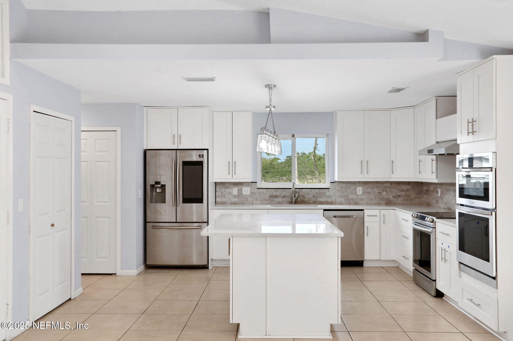12228 Smoke Ridge Circle South Jacksonville, FL 32225 - Photo 16 of 50 a kitchen with white cabinets and stainless steel appliances