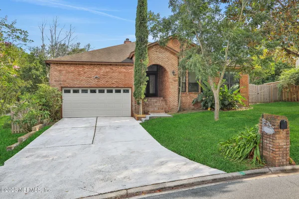 a front view of a house with a garden and plants