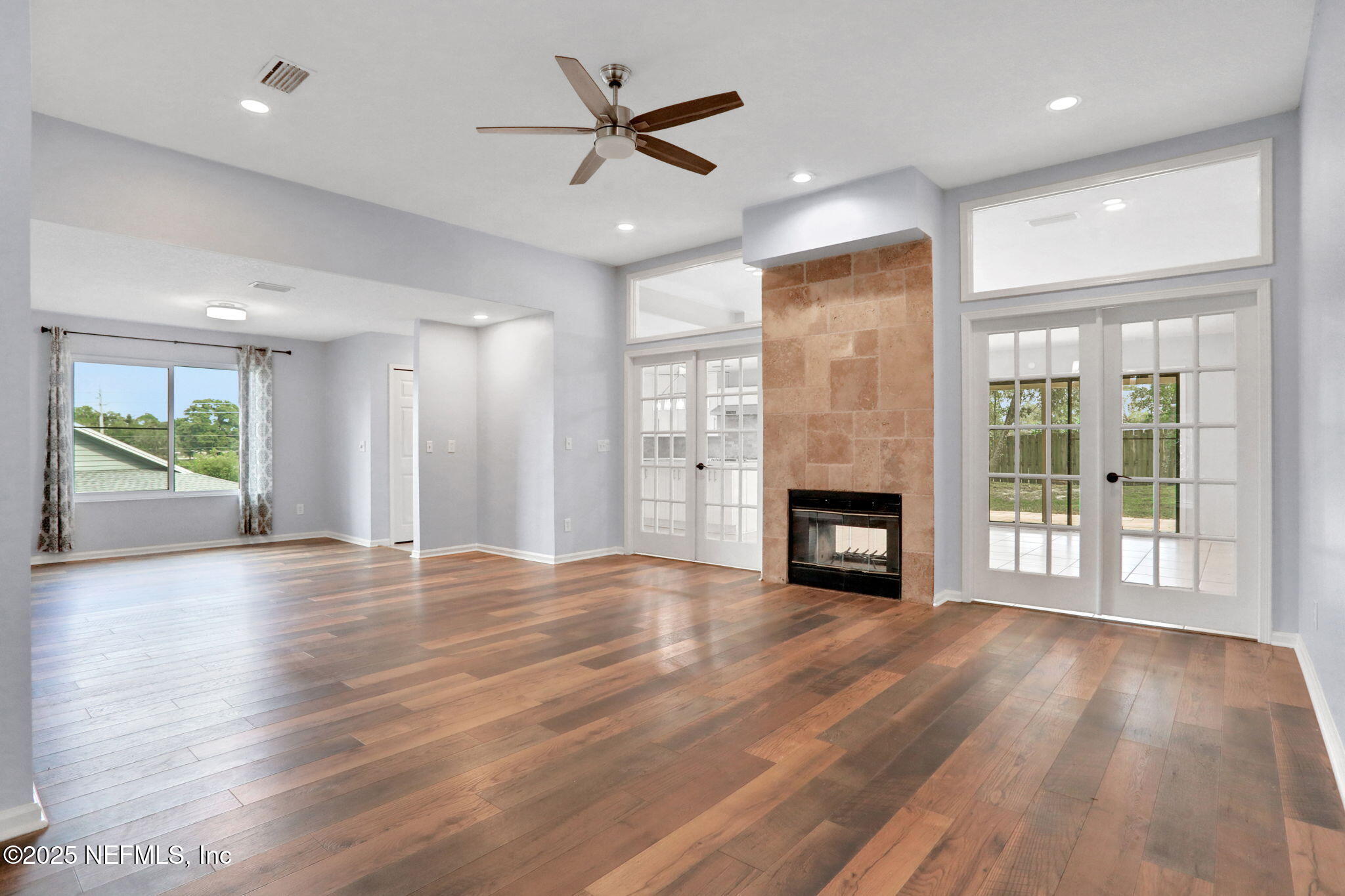 12228 Smoke Ridge Circle South Jacksonville, FL 32225 - Photo 21 of 50 an empty room with windows a fireplace and wooden floor