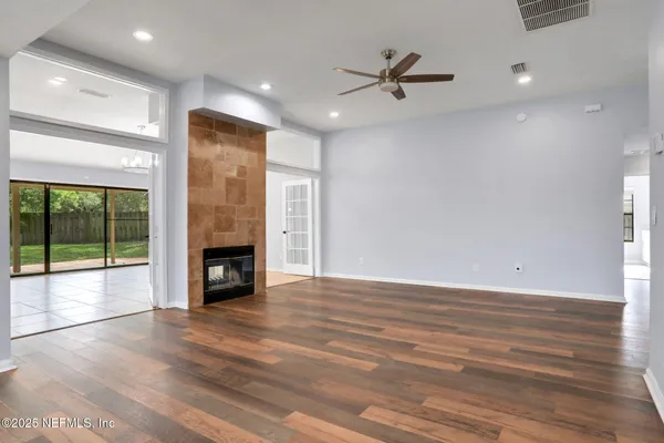 a view of an empty room with a fireplace and a window
