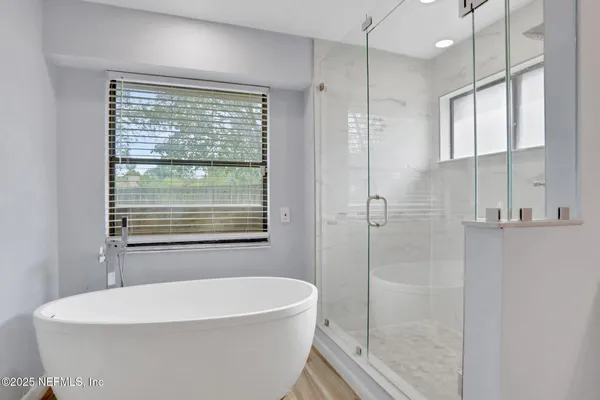 a white bath tub sitting next to a shower