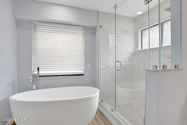 a white bath tub sitting next to a shower