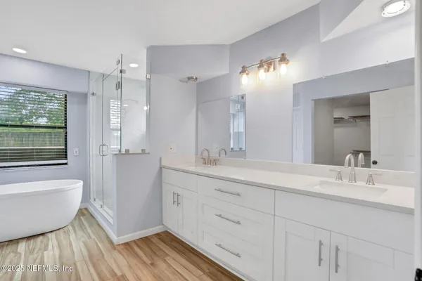 a bathroom with a double vanity sink a mirror and a shower