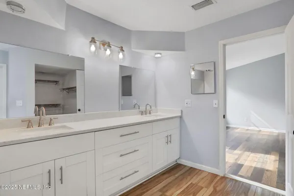 a bathroom with a double vanity sink and a mirror