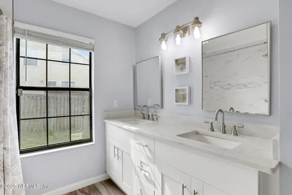 a bathroom with a double vanity sink and a window