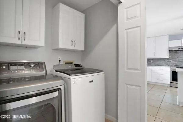 a kitchen with a stove and white cabinets