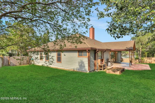a front view of a house with a garden and trees