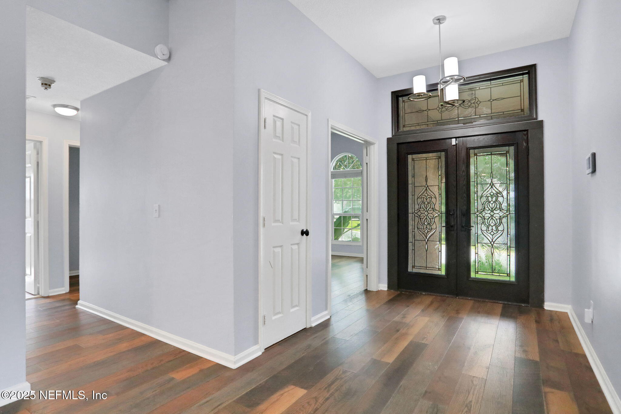 12228 Smoke Ridge Circle South Jacksonville, FL 32225 - Photo 5 of 50 a view of a hallway with wooden floor and a chandelier